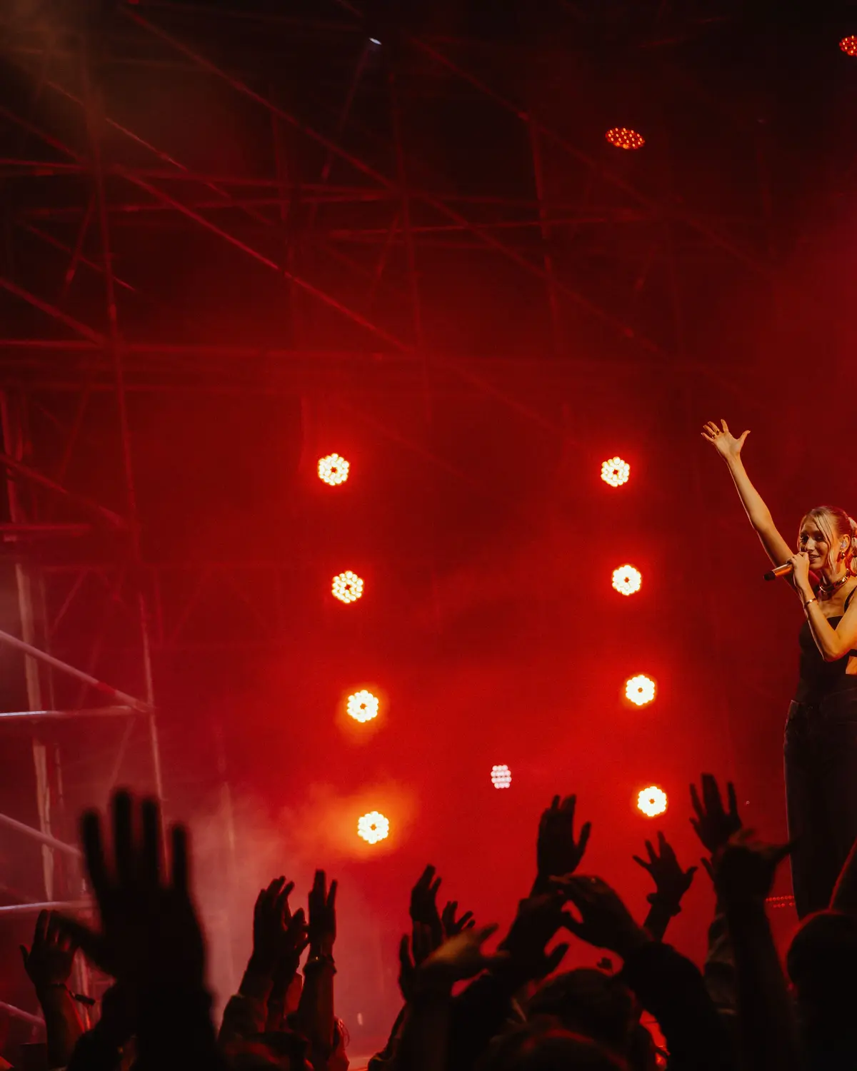 Red stage lights over a dancing crowd